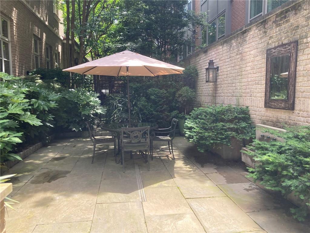 2440 Peachtree Road Northwest, Unit 9 Atlanta, GA 30305 - Photo 16 of 48 a view of a patio with chairs under an umbrella