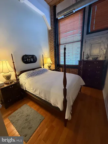 a bedroom with a bed and dresser with mirror