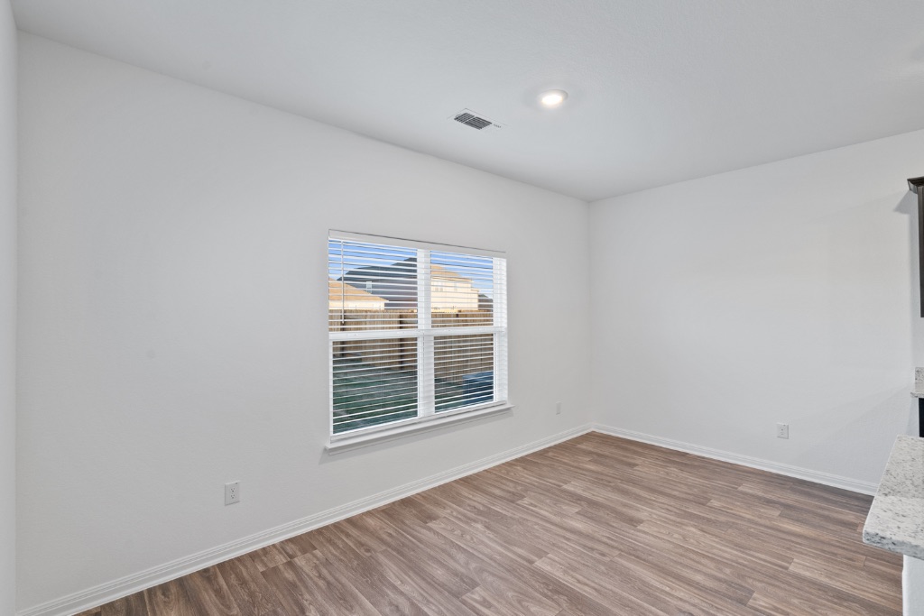 14013 John Aregood Pass Elgin, TX 78621 - Photo 11 of 31 a view of an empty room with wooden floor and a window