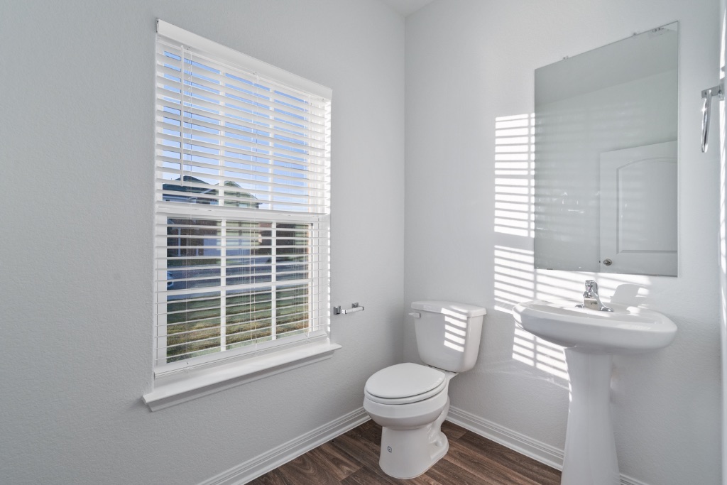 14013 John Aregood Pass Elgin, TX 78621 - Photo 12 of 31 a bathroom with a toilet a sink and a window