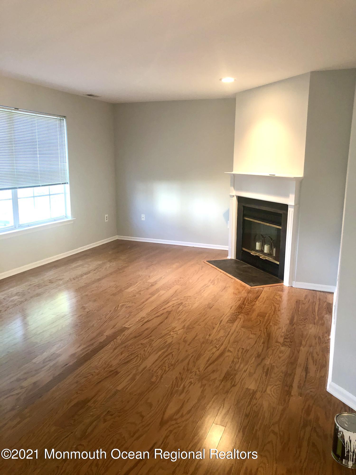 5 Racquet Road Wall, NJ 07719 - Photo 3 of 21 an empty room with wooden floor fireplace and windows