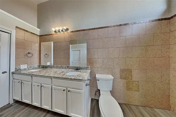 a bathroom with a granite countertop sink a toilet and a mirror