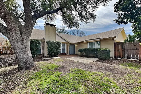 a view of a house with a tree in the yard