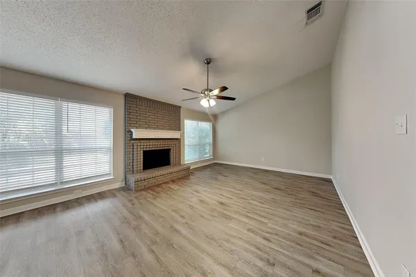 wooden floor in an empty room with a fireplace