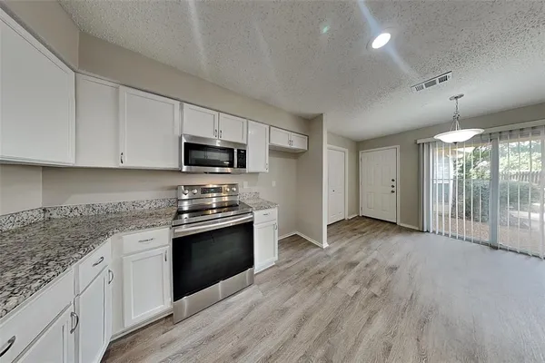 a kitchen with stainless steel appliances granite countertop a stove and a sink