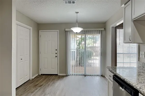 a view of a room with wooden floor and chandelier