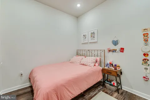 a bedroom with a bed and a wooden floor