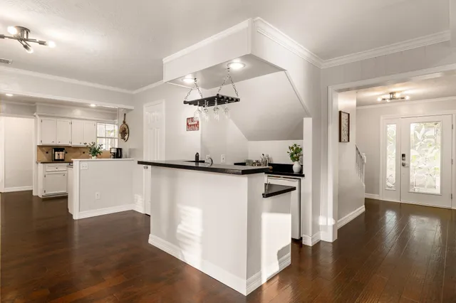 a kitchen with granite countertop a refrigerator and a stove top oven