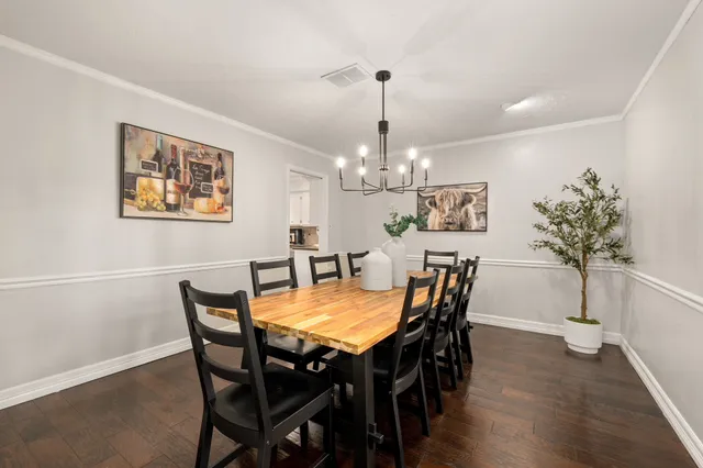 a view of a dining room with furniture wooden floor and chandelier