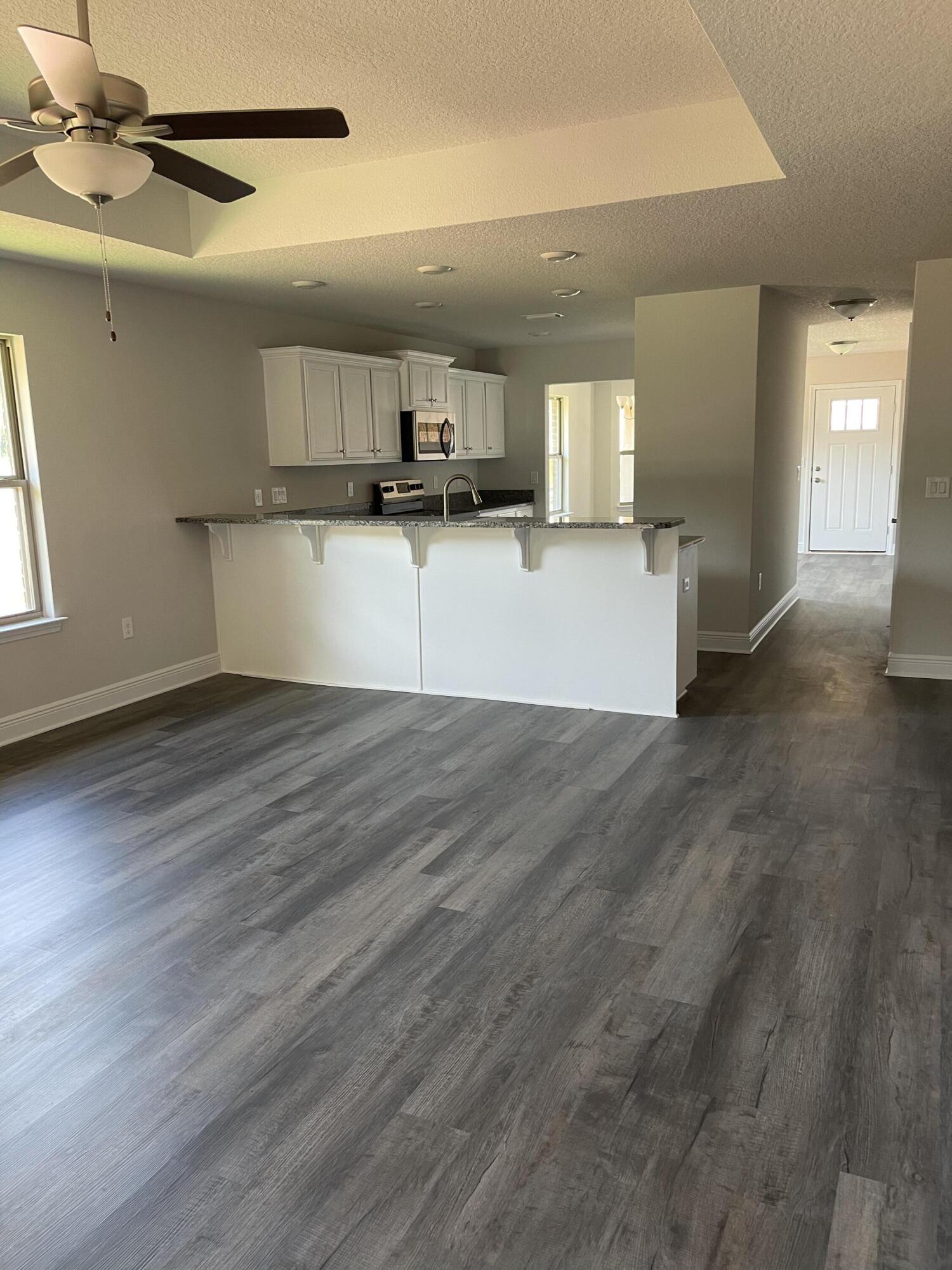 106 Ridgeway Circle Crestview, FL 32536 - Photo 12 of 25 a view of kitchen and empty room with wooden floor
