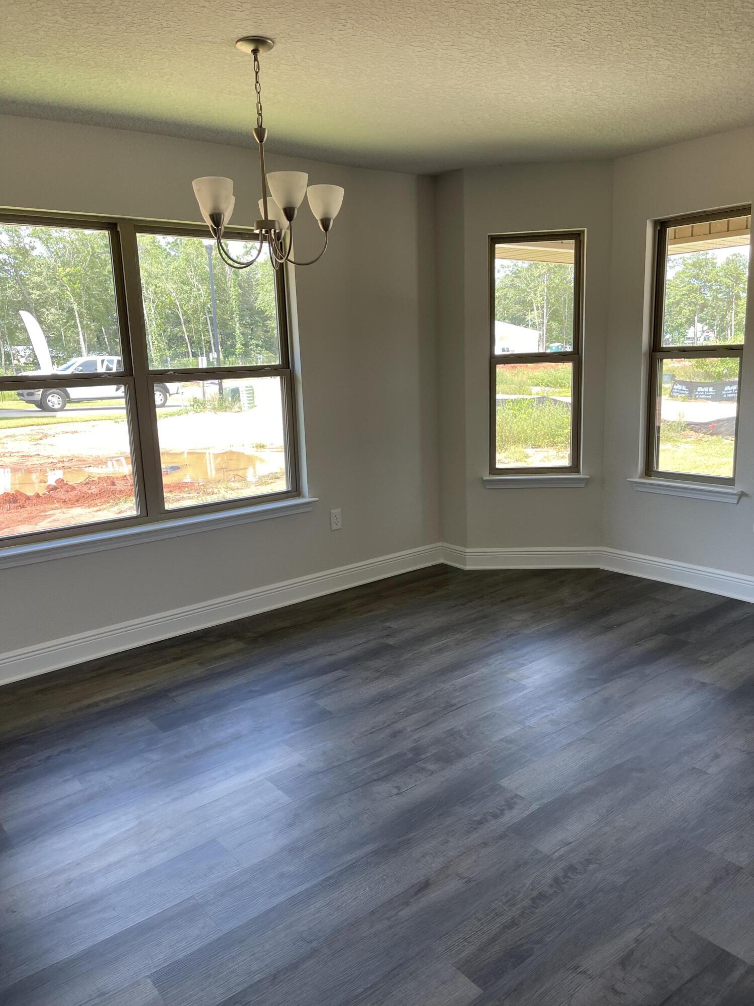 106 Ridgeway Circle Crestview, FL 32536 - Photo 5 of 25 an empty room with wooden floor and windows