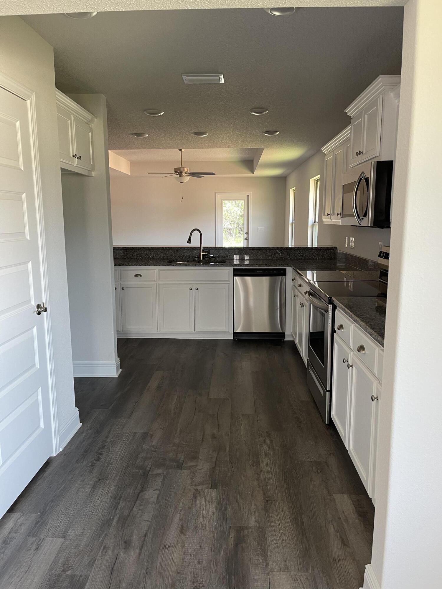 106 Ridgeway Circle Crestview, FL 32536 - Photo 6 of 25 a large kitchen with stainless steel appliances granite countertop a lot of counter space and wooden floor