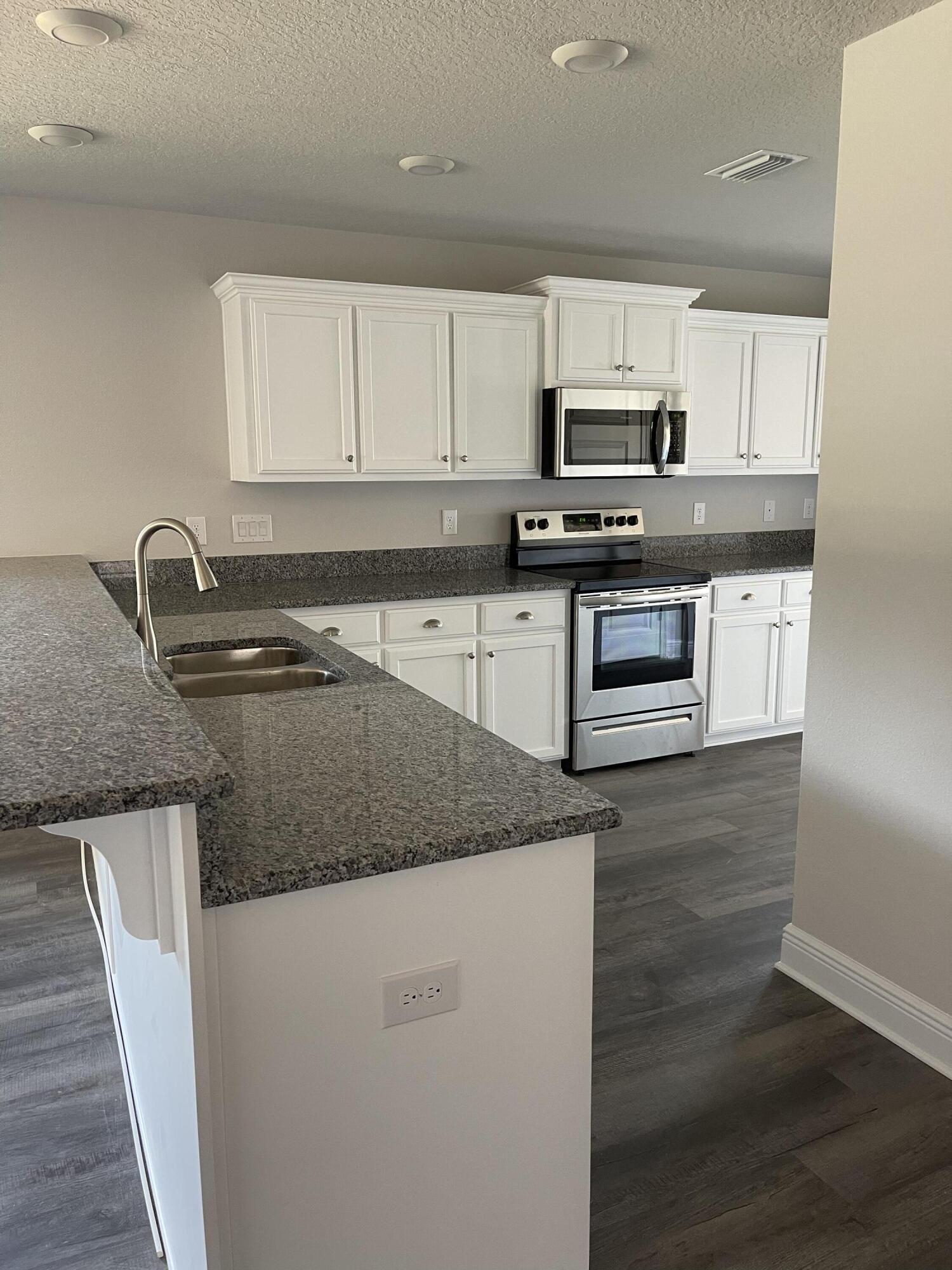 106 Ridgeway Circle Crestview, FL 32536 - Photo 10 of 25 a kitchen with granite countertop a sink a stove and cabinets