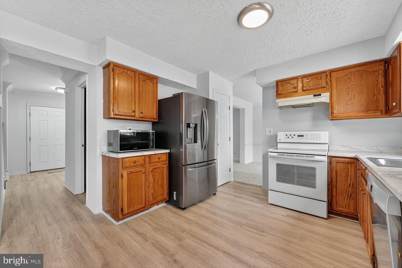 212 Chinnick Avenue Hamilton, NJ 08619 - Photo 7 of 17 a kitchen with a refrigerator stove and wooden cabinets