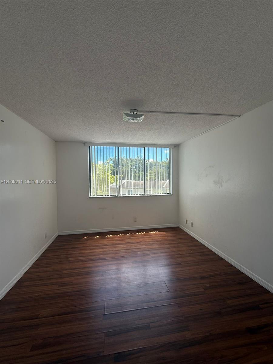 4222 Inverrary Boulevard, Unit 4215 Lauderhill, FL 33319 - Photo 17 of 20 a view of an empty room with wooden floor and a window