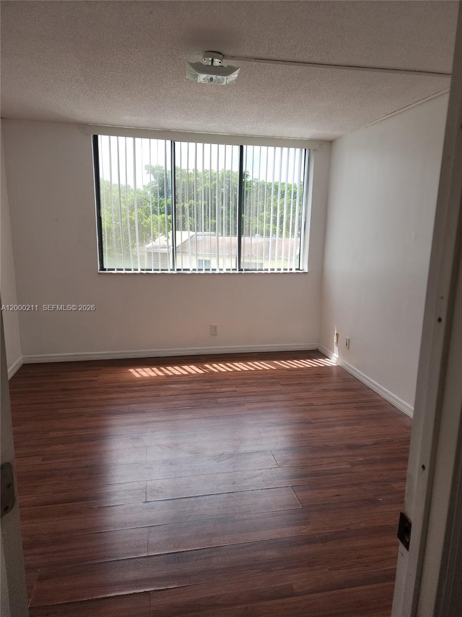 4222 Inverrary Boulevard, Unit 4215 Lauderhill, FL 33319 - Photo 10 of 20 an empty room with wooden floor and windows