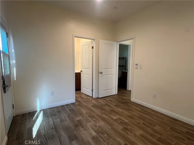 an empty room with wooden floor and a bathroom