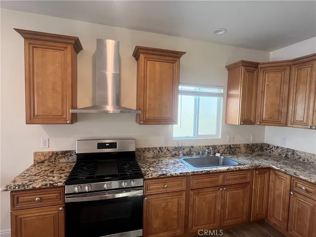 a kitchen with stainless steel appliances granite countertop a stove a sink and a microwave