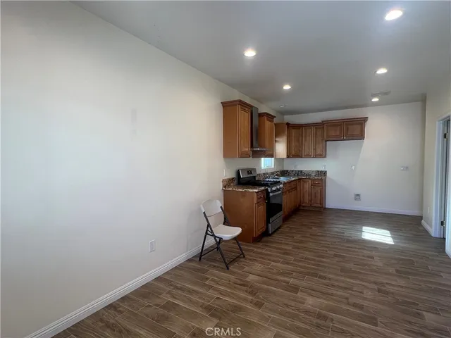 a kitchen with wooden floor and white stainless steel appliances