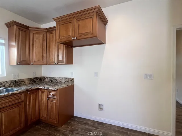 a kitchen with granite countertop wood cabinets and a stove