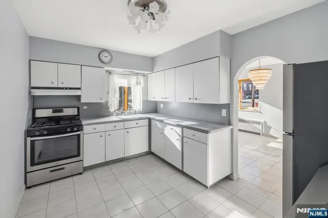 a kitchen with granite countertop white cabinets and white appliances