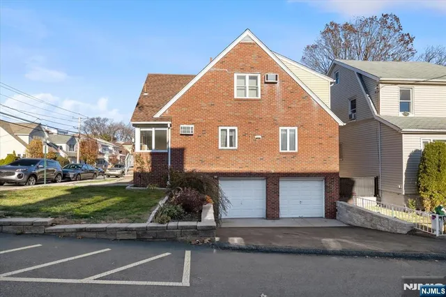 a view of a brick house with a yard next to a road