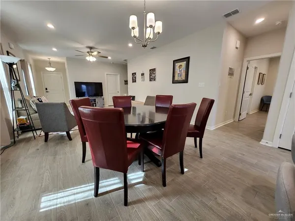 a view of a dining room with furniture a chandelier and wooden floor