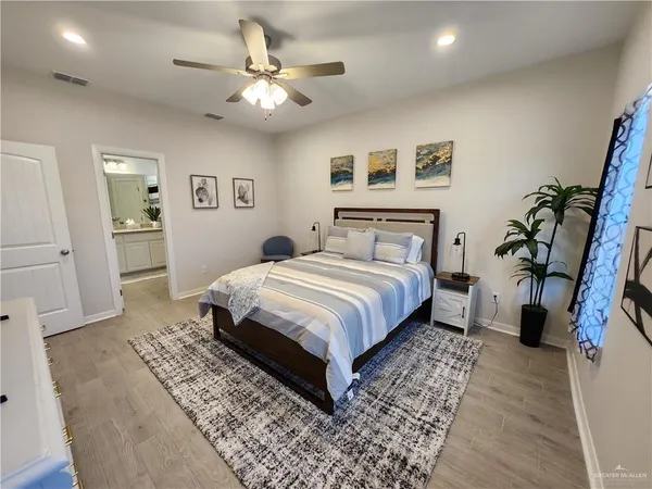 a bedroom with a large bed and a chandelier