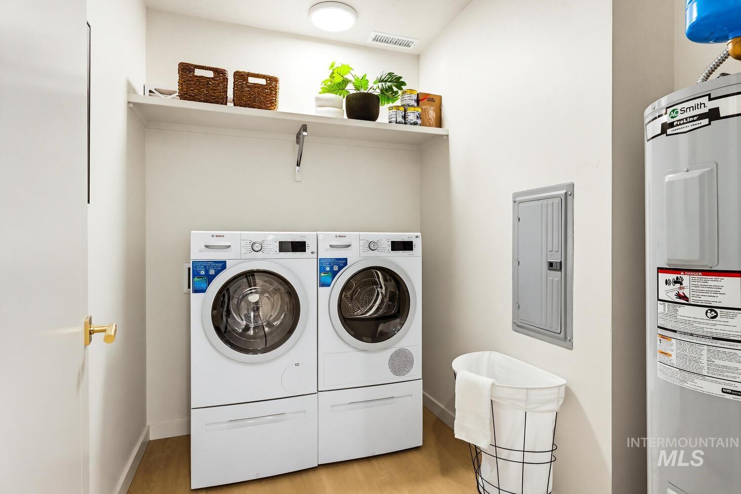 4250 Haystack, Unit 104 Boise, ID 83716 - Photo 28 of 49 Laundry area featuring electric panel, electric water heater, light wood-type flooring, and washing machine and dryer