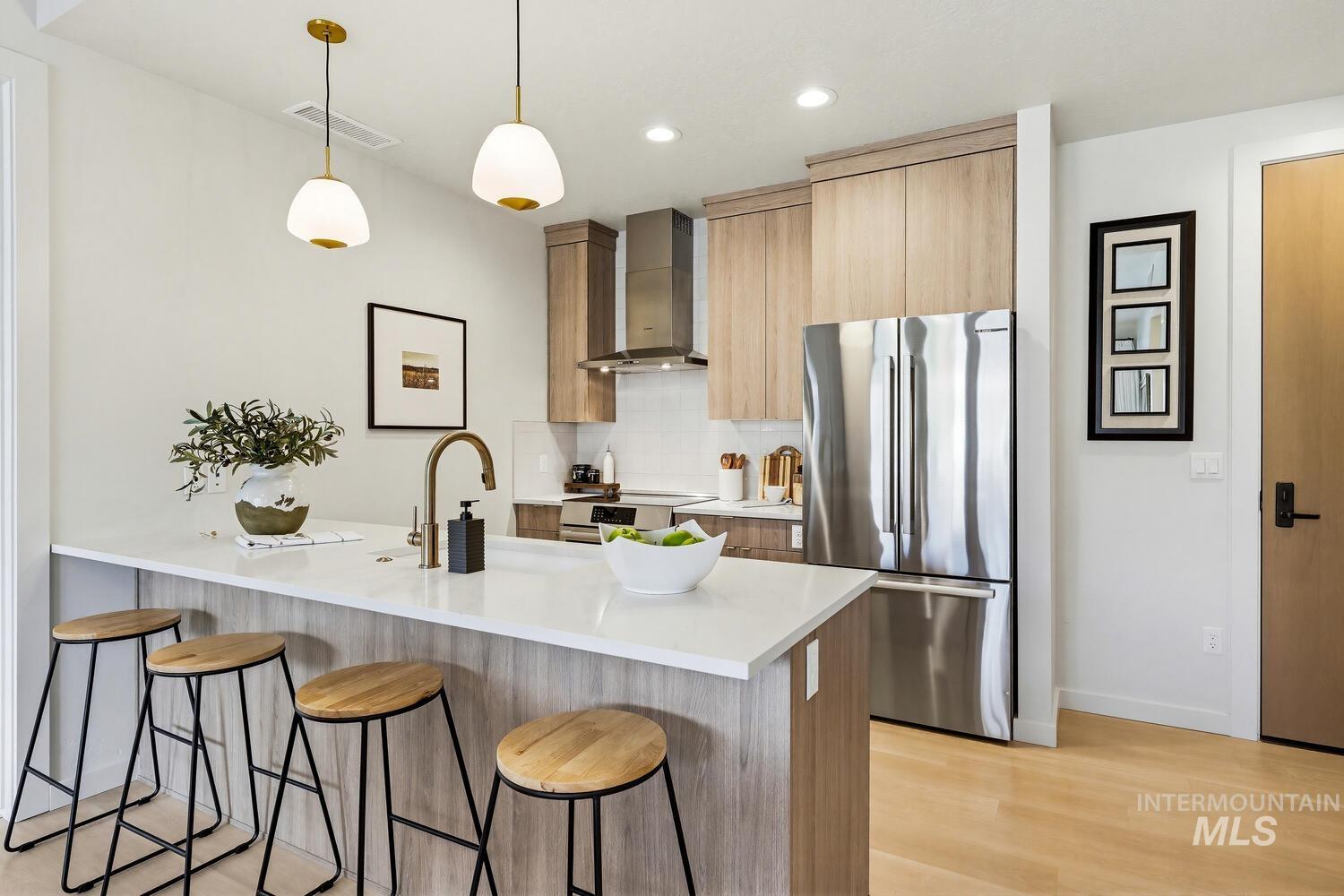 4250 Haystack, Unit 104 Boise, ID 83716 - Photo 3 of 49 Kitchen featuring a kitchen bar, a peninsula, stainless steel appliances, modern cabinets, and decorative light fixtures