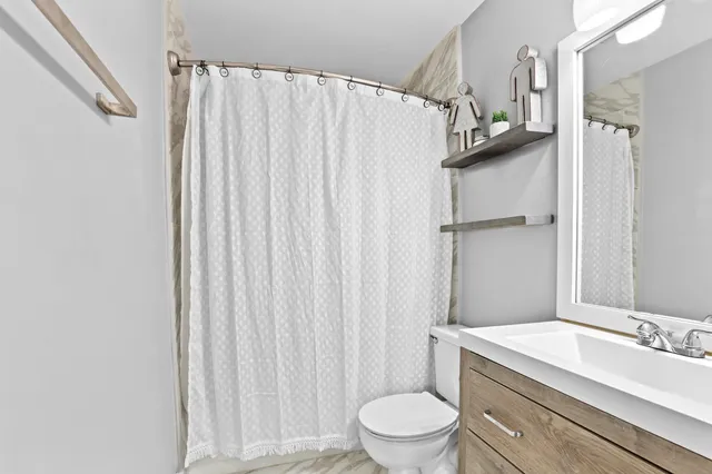 a bathroom with a granite countertop sink toilet and shower