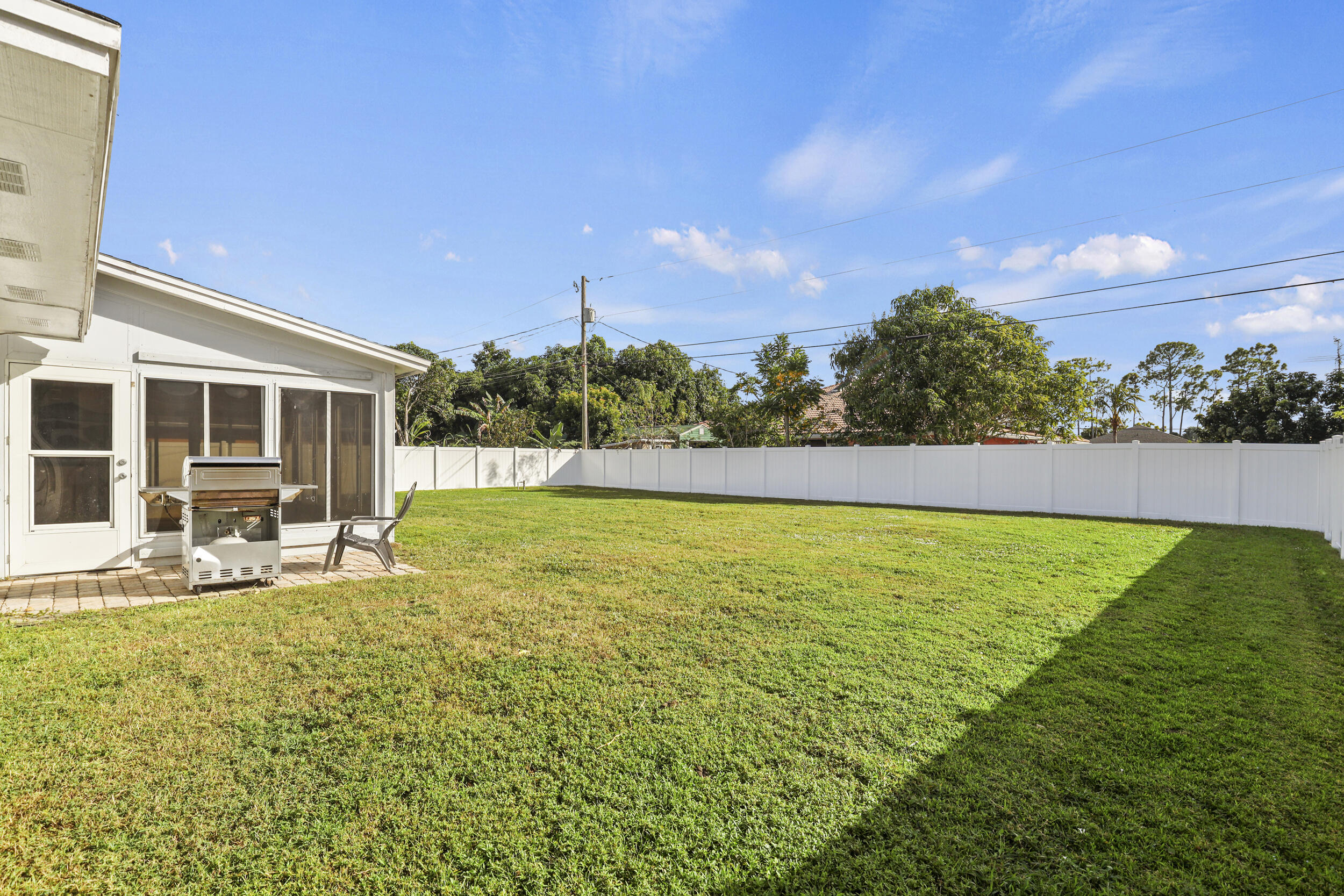 1542 Southwest Dycus Avenue Port St. Lucie, FL 34953 - Photo 31 of 34 a view of a swimming pool with lawn chairs and plants