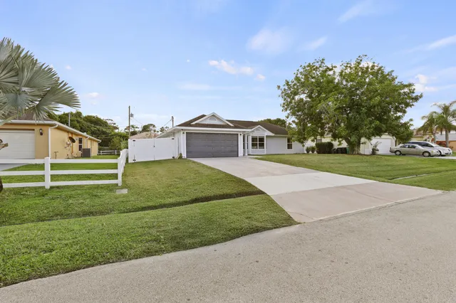 a view of a house with a big yard and large trees