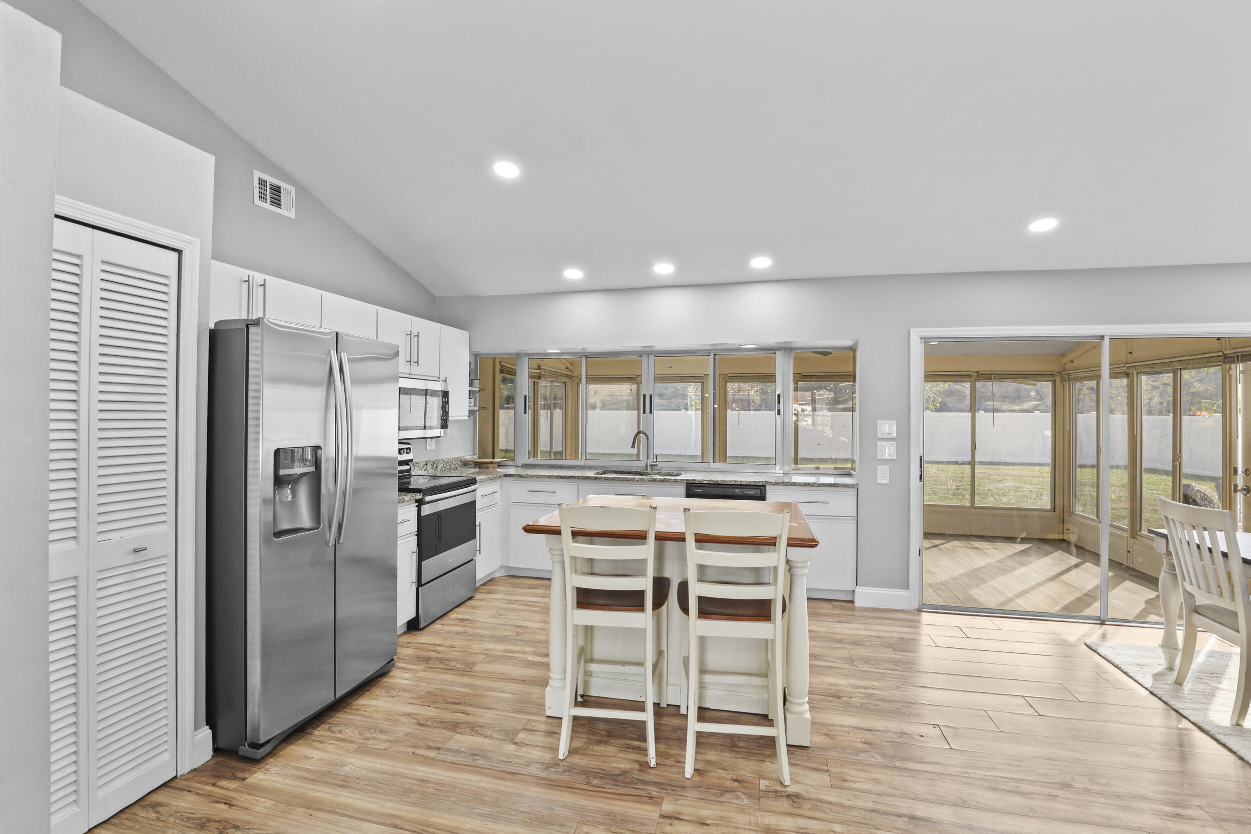 1542 Southwest Dycus Avenue Port St. Lucie, FL 34953 - Photo 6 of 34 a view of a kitchen with dining area wooden floor and stainless steel appliances