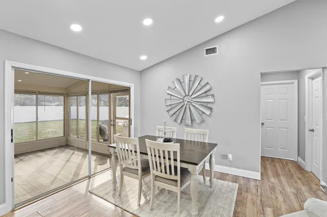 a dining room with furniture a chandelier and wooden floor