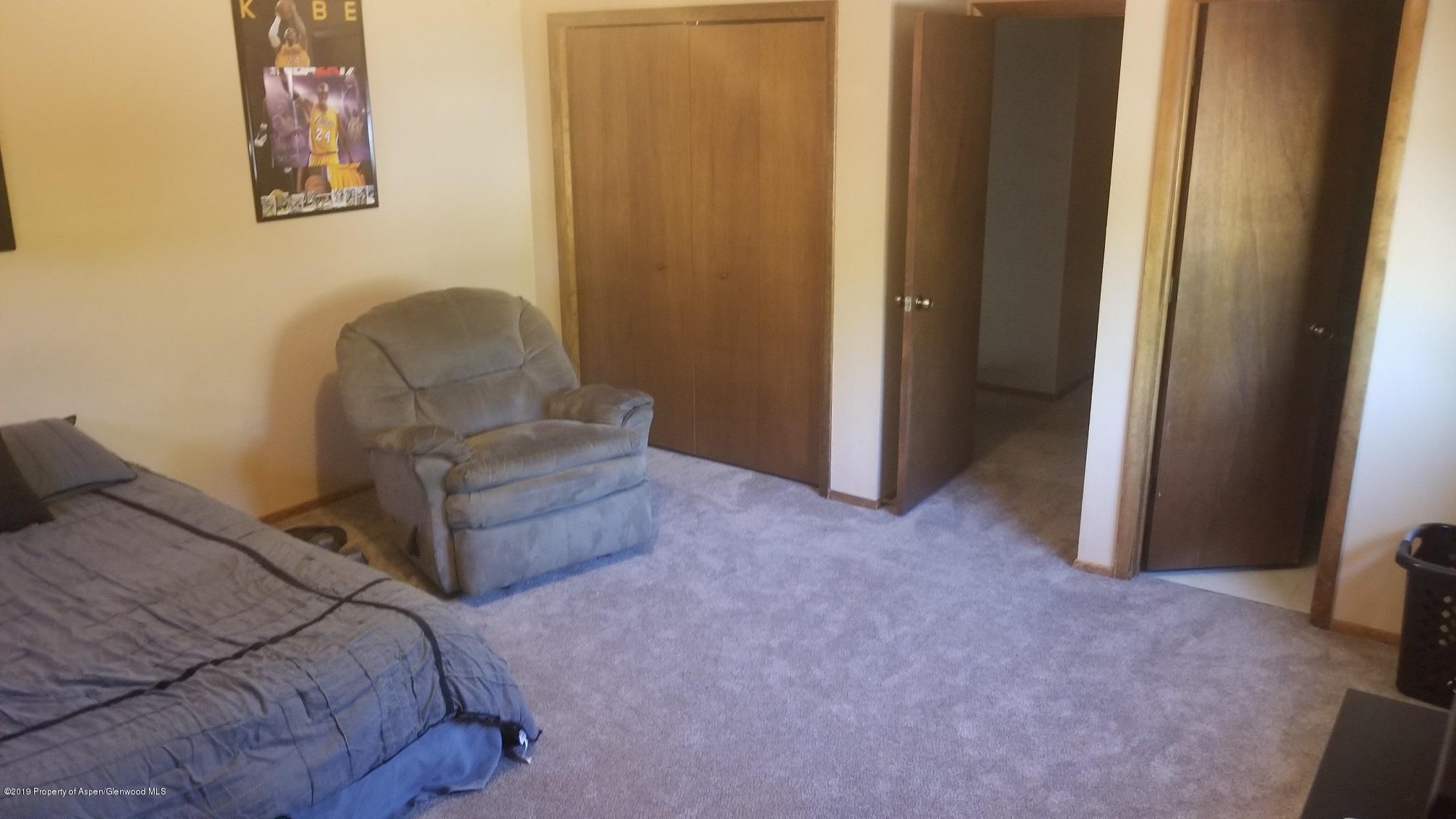1428 Jays Avenue Rifle, CO 81650 - Photo 8 of 14 a bedroom with a bed and a chair