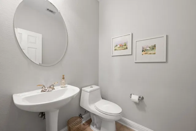 a bathroom with a toilet a sink and mirror