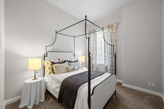 a bedroom with a bed a chandelier and a window