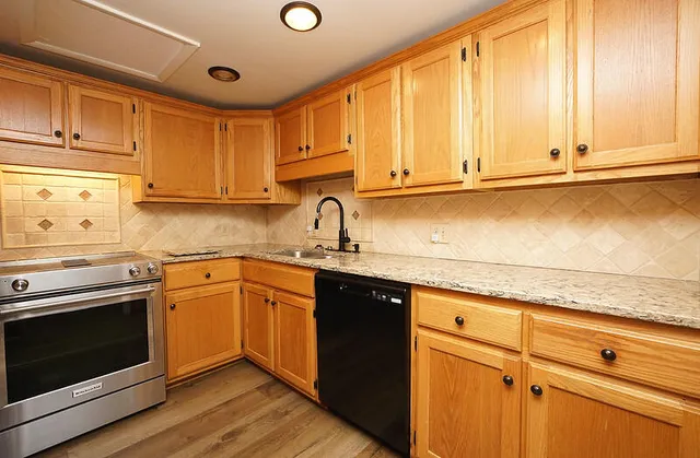 a kitchen with stainless steel appliances granite countertop a sink stove and cabinets
