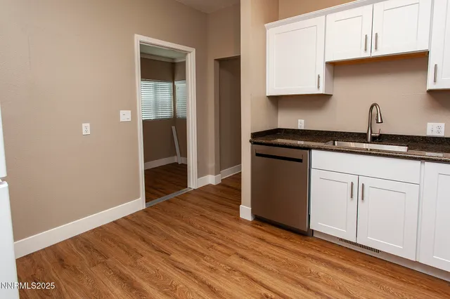 a kitchen with granite countertop wooden cabinets and a wooden floor