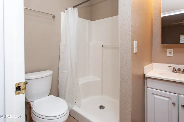 a bathroom with a shower a toilet and a sink