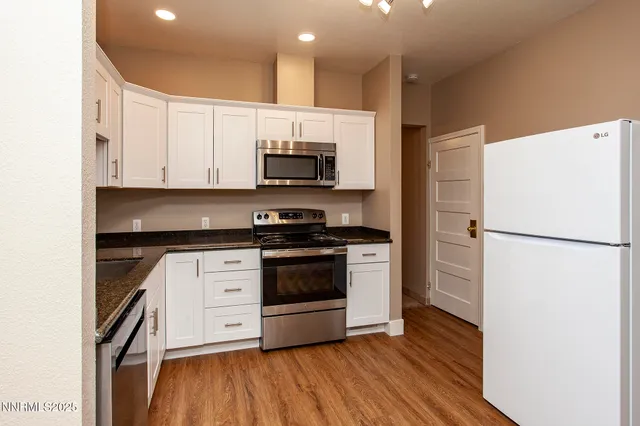 a kitchen with stainless steel appliances a refrigerator sink and microwave