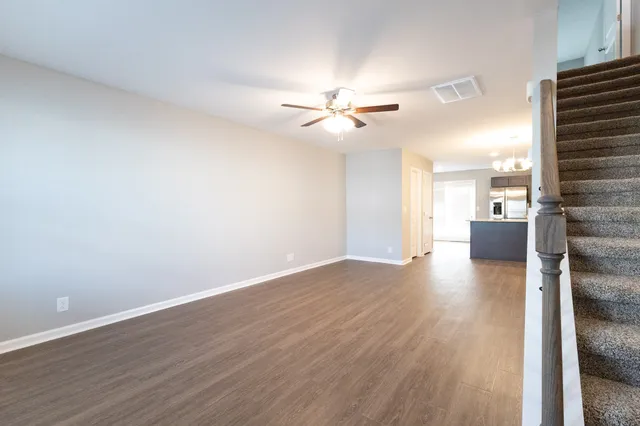 a view of a livingroom with a hardwood floor and a ceiling fan
