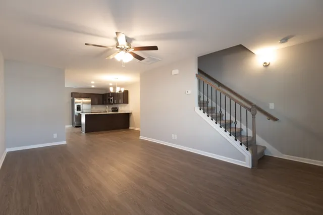 a view of a livingroom with a ceiling fan and hardwood floor