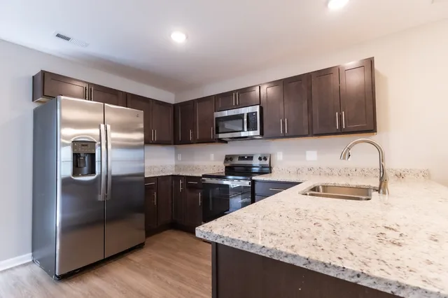 a kitchen with granite countertop wooden cabinets and stainless steel appliances