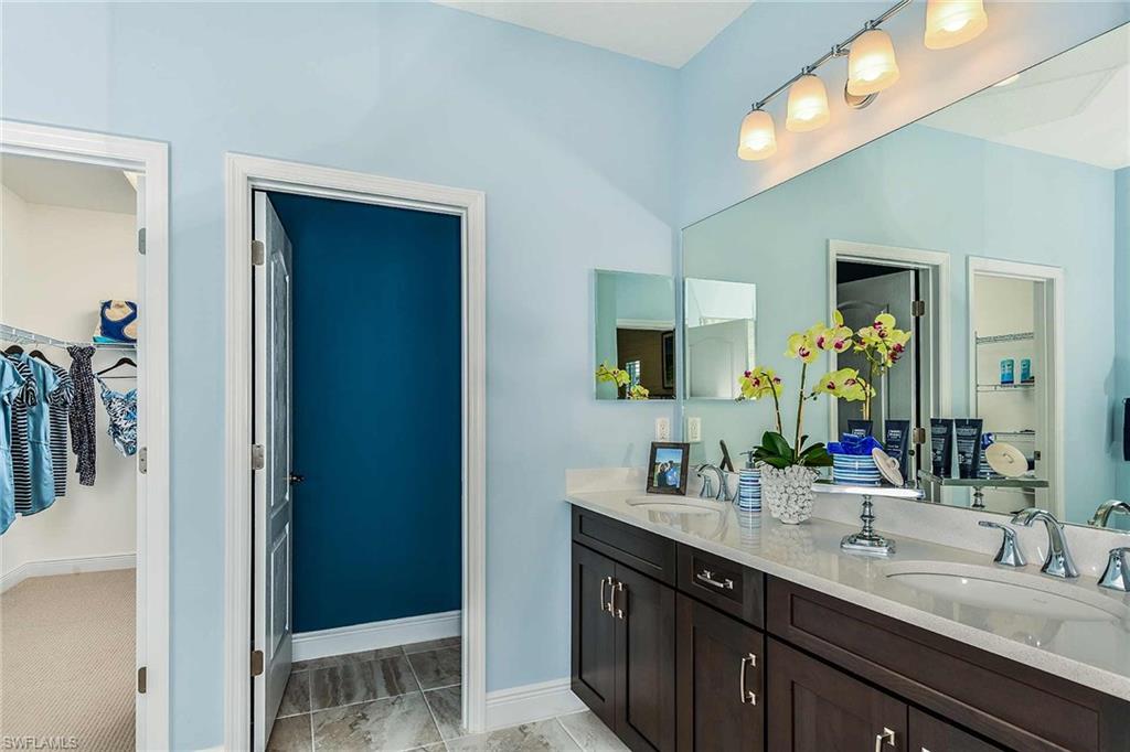 4551 Centaurus Circle Naples, FL 34120 - Photo 16 of 26 a bathroom with a double vanity sink and a mirror