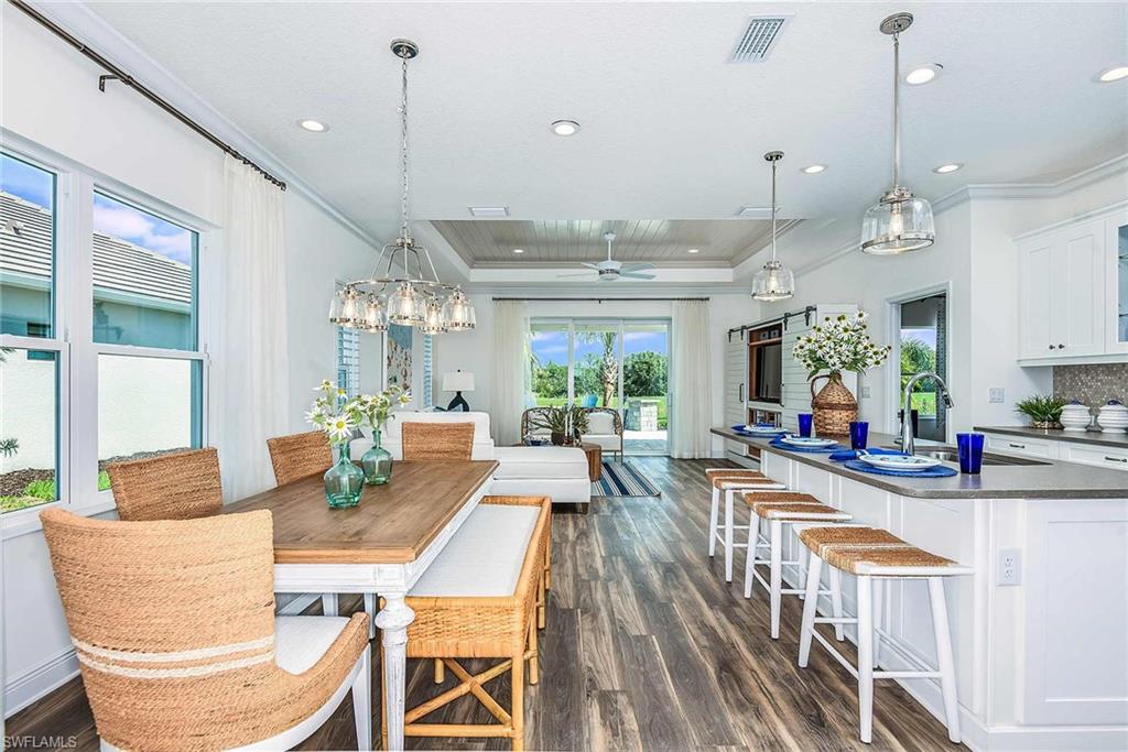 4551 Centaurus Circle Naples, FL 34120 - Photo 4 of 26 a view of a dining room and livingroom with furniture wooden floor a chandelier