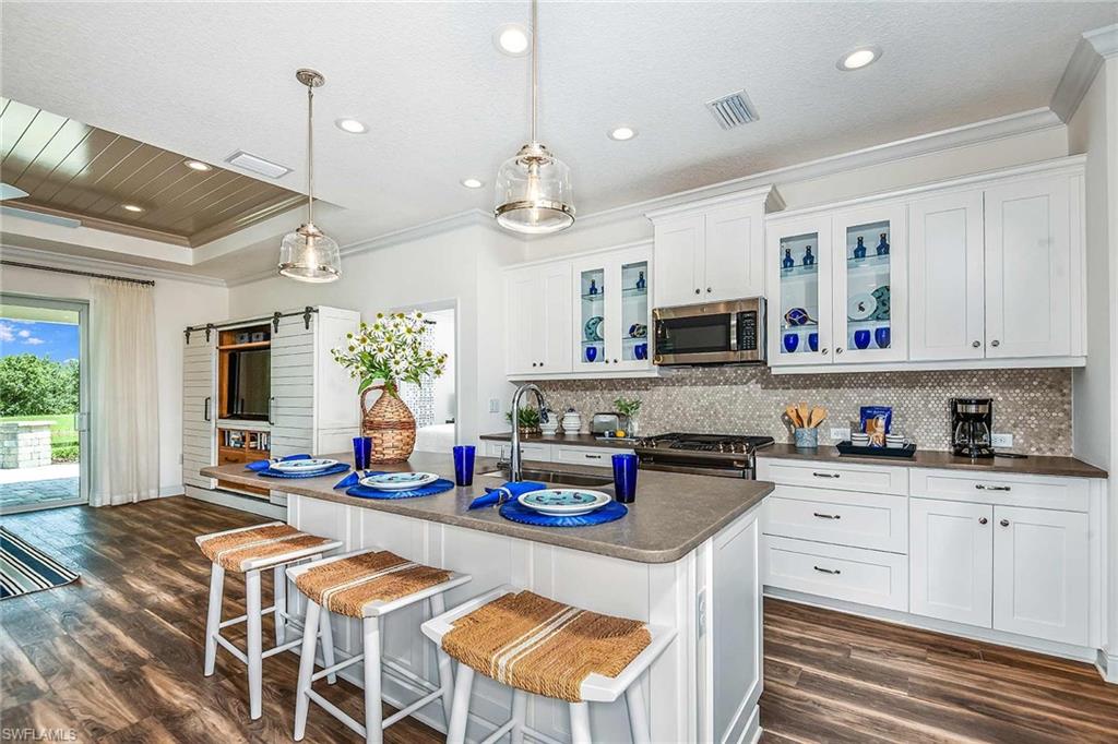 4551 Centaurus Circle Naples, FL 34120 - Photo 6 of 26 a kitchen with stainless steel appliances granite countertop a stove and cabinets