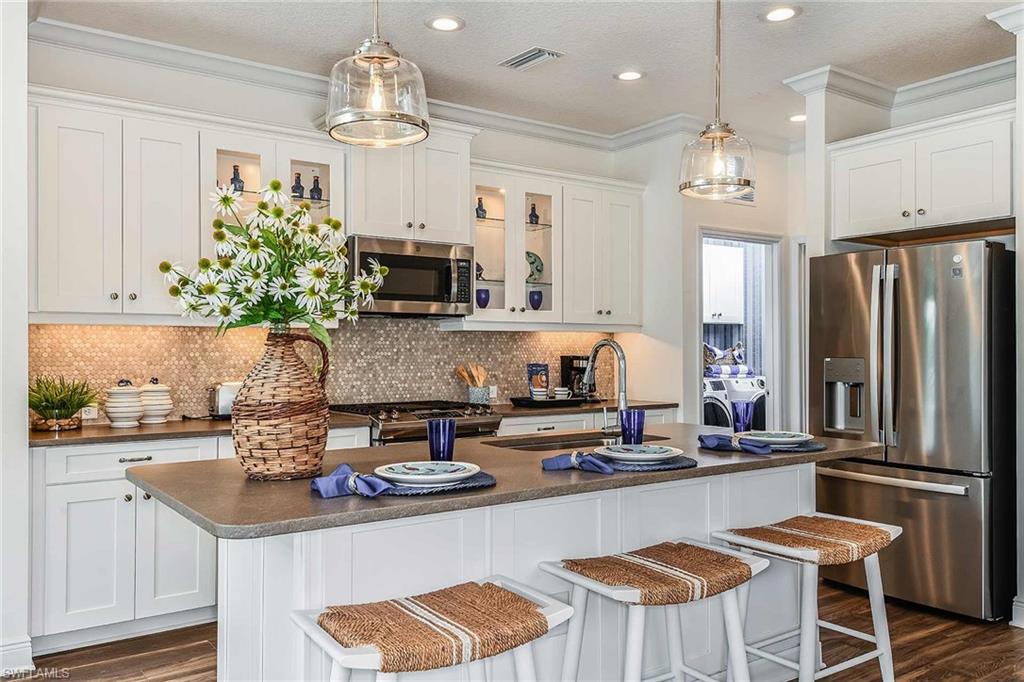 4551 Centaurus Circle Naples, FL 34120 - Photo 10 of 26 a kitchen with kitchen island granite countertop a sink and refrigerator
