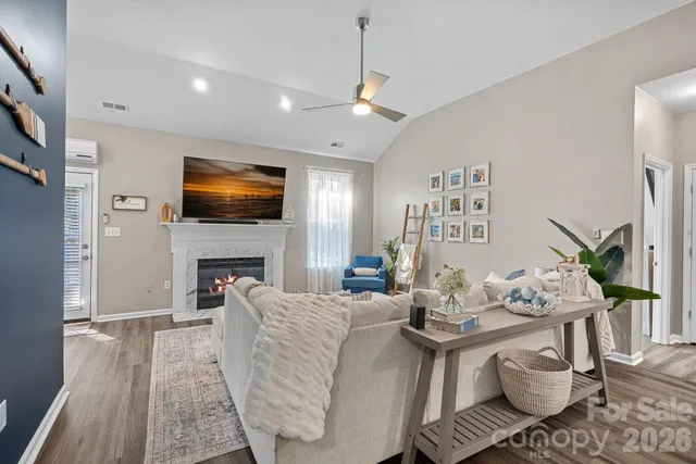 a living room with furniture a flat screen tv and a fireplace